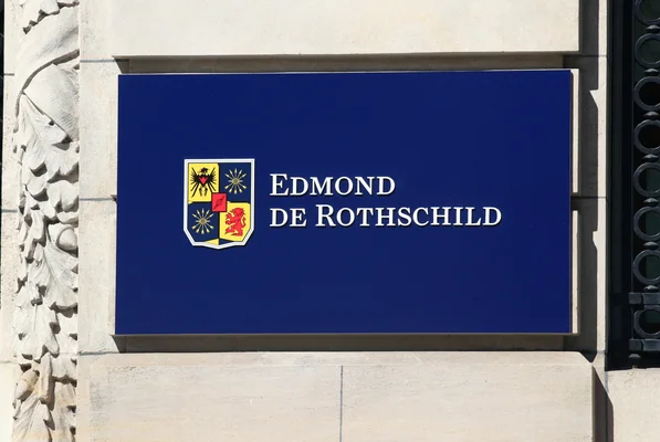 Enseigne bleue 'Edmond de Rothschild' accrochée sur une façade de pierre.