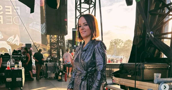 Alizée en robe argentée sur une scène de festival, avec l'équipe technique en arrière-plan.