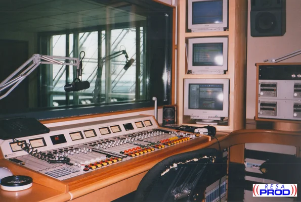Studio de radio Skyrock avec une grande table de mixage et deux microphones.