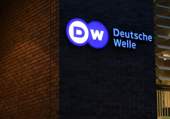 La façade d'un bâtiment avec le logo illuminé de Deutsche Welle.