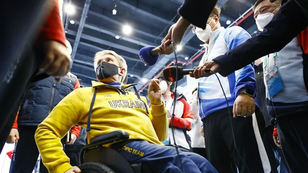 Un athlète ukrainien en fauteuil roulant répondant aux questions des journalistes.