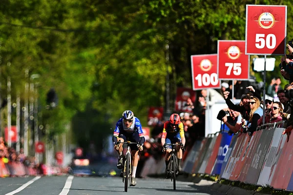 Remco Evenepoel célébrant sa victoire avec le trophée de l'Amstel Gold Race.