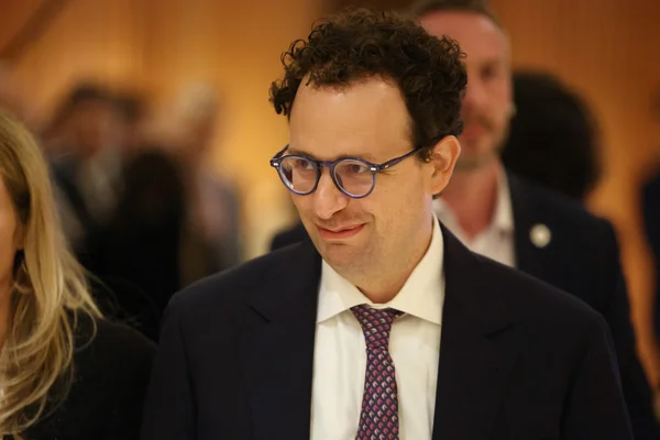 Un smartphone affichant le logo d'Anthropic et l'interface de Claude sur fond rouge étoilé.