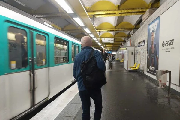 Voyageur sur le quai attendant le passage de la rame dans la station.