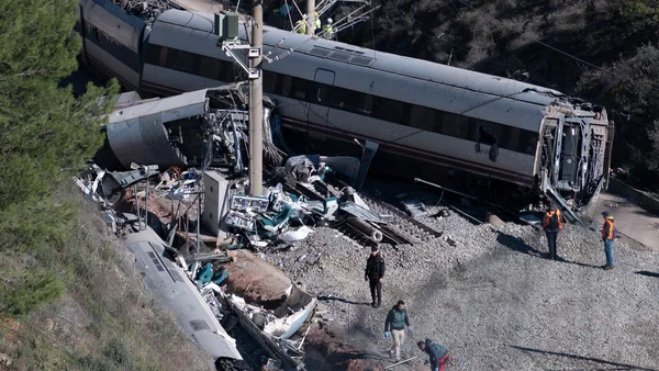 Les wagons renversés et la carcasse tordue d'un train gisant au milieu des débris dans une zone boisée, suite à la grave collision en Espagne.