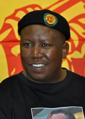 Julius Malema levant le poing lors d'une manifestation avec ses partisans.