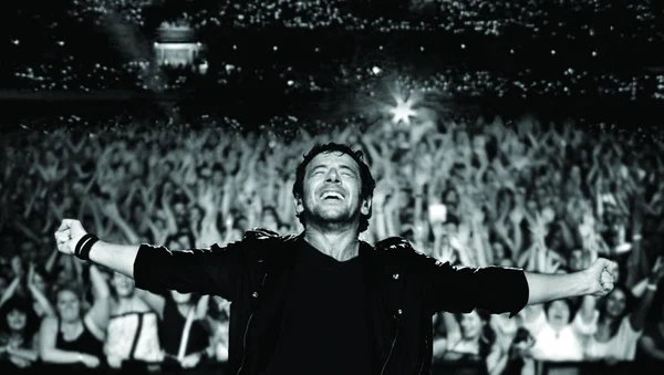 Patrick Bruel lors d'un concert, accueilli par une foule nombreuse.