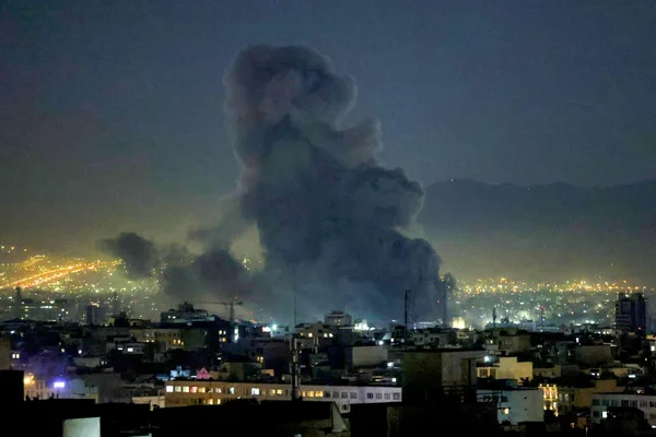 Une colonne de fumée s'élevant au-dessus d'une ville iranienne après une vague de frappes israéliennes.