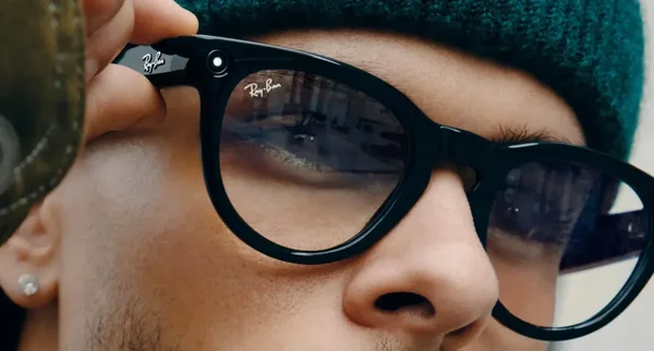 Une personne ajustant des lunettes connectées Ray-Ban Meta sur son visage.