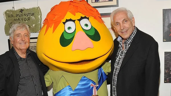 Deux hommes posant avec la marionnette H.R. Pufnstuf.