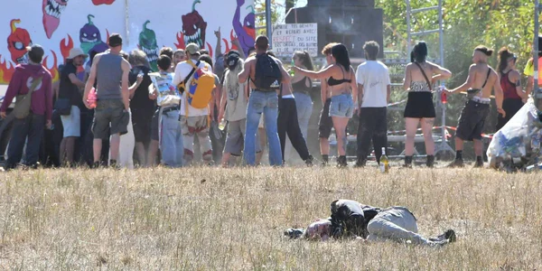 Scène extérieure avec fresque colorée et personne allongée sur le sol.