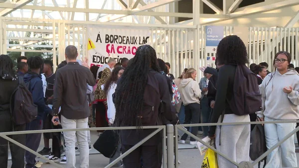 Manifestation devant un collège avec une bannière revendicative sur l'éducation à Bordeaux.