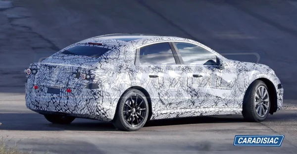 Prototype camouflé de la Mercedes Classe C électrique vu de trois-quarts arrière.