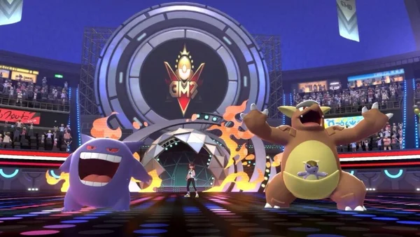 Un dresseur accompagné d'Ectoplasma et Kangourex sur scène devant le logo 'GMP'.