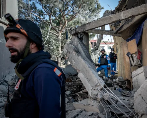 Un secouriste en casque et veste bleue parmi les décombres après une attaque israélienne au Liban.