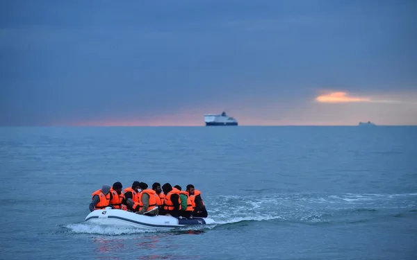 Des migrants en gilets de sauvetage occupent une embarcation pneumatique en Manche.