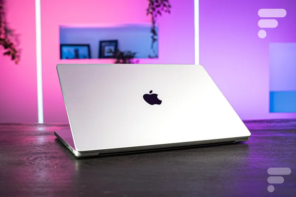 MacBook Pro mis en scène avec un éclairage néon coloré.