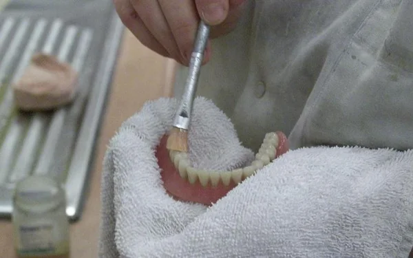 Visage rapproché d'une personne âgée présentant des dents manquantes.
