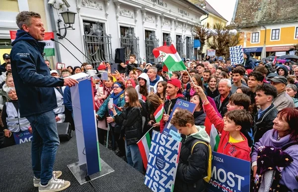 Péter Magyar s'adressant à une large foule de partisans avec des drapeaux et des affiches TISZA.