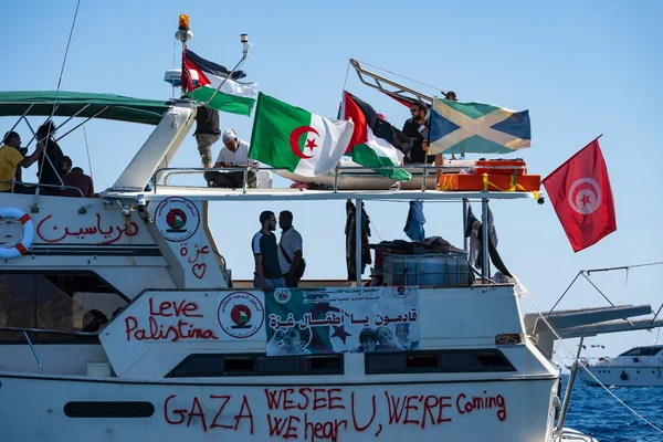 Navire de la flottille pour Gaza avec des messages de soutien et divers drapeaux internationaux.