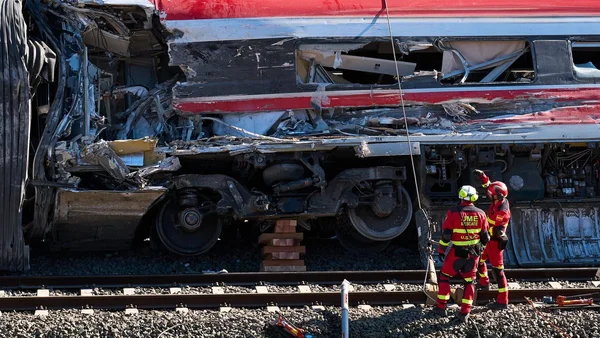 Déraillement d'un train en Espagne avec des wagons renversés et des corps recouverts de couvertures sur le ballast.