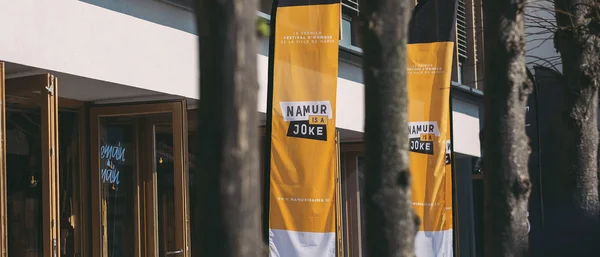 Signalétique jaune vif annonçant le festival Namur is a Joke dans les rues de la ville.