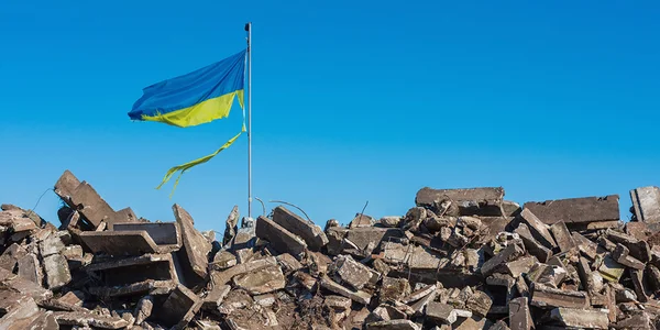 Le drapeau de l'Ukraine flottant au-dessus des ruines de béton.