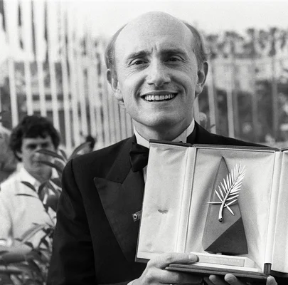 Michel Blanc en smoking tenant son trophée de la Palme d'or.