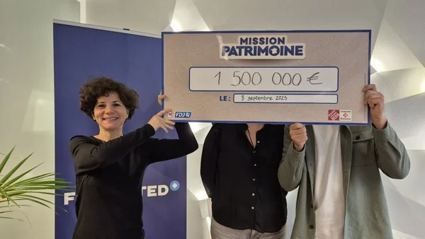 Trois gagnants exibant un chèque de 1,5 million d'euros pour Mission Patrimoine, retrouvé dans une hotte de cuisine.