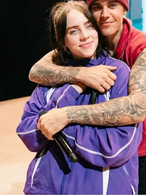 Justin Bieber et Billie Eilish partageant une étreinte chaleureuse sur scène.