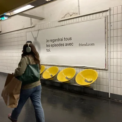 Passante devant une affiche publicitaire pour friend.com.