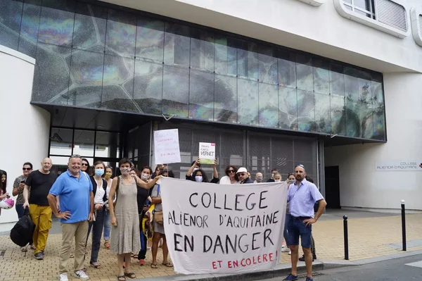 Manifestation devant le collège Aliénor d'Aquitaine avec une banderole de protestation.