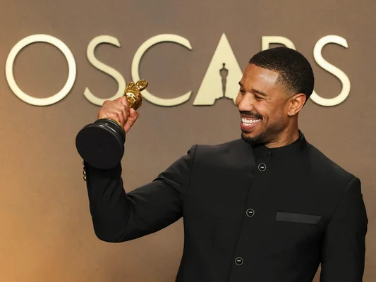 Michael B. Jordan sacré meilleur acteur pour « Sinners » tenant sa récompense lors des Oscars 2026.