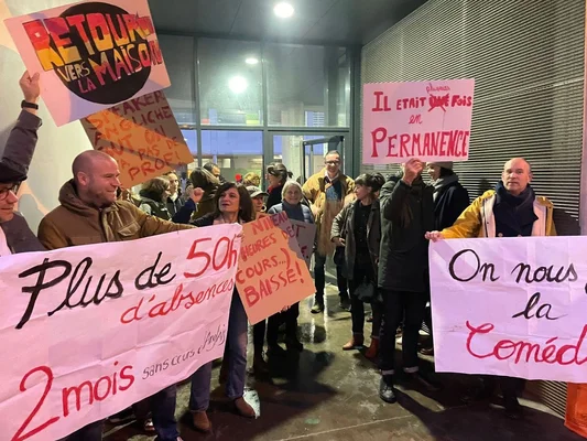 Parents d'élèves protestant la nuit avec des pancartes contre le non-remplacement des professeurs.