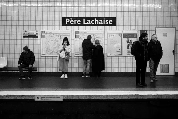 Quai de la station Père Lchaise avec des voyageurs consultant les informations.