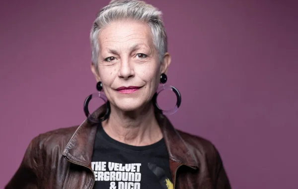 Lio dans un style rock avec veste en cuir et boucles d'oreilles créoles.