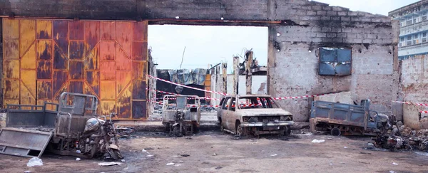 Dégâts causés par des groupes militants violents sur un site industriel, avec véhicules incendiés.