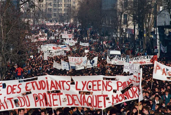 Manifestation d'étudiants et de lycéens dans une ville, avec de nombreuses banderoles déployées.