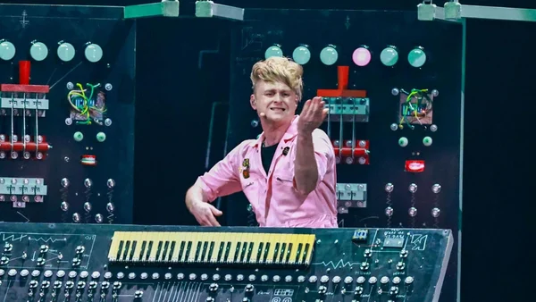 Sam Bartle (LOOK MUM NO COMPUTER) derrière son synthétiseur sur mesure, souriant avant sa performance.