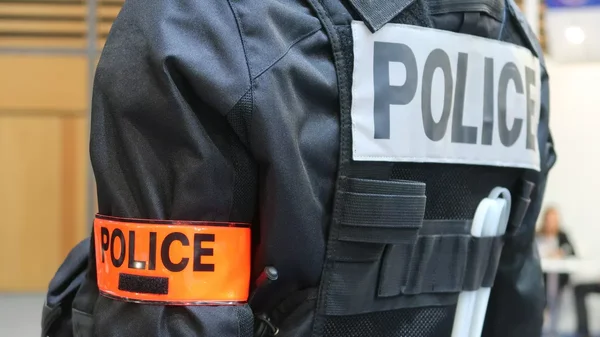 Un policier en tenue d'intervention, de dos.