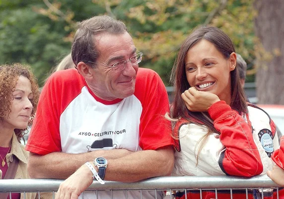 Jean-Pierre Pernaut et Nathalie Marquay-Pernaut souriant lors d'un événement en extérieur.