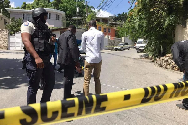 Un policier derrière un ruban de scène de crime jaune surveille la rue après l'assassinat du président haïtien Jovenel Moïse.