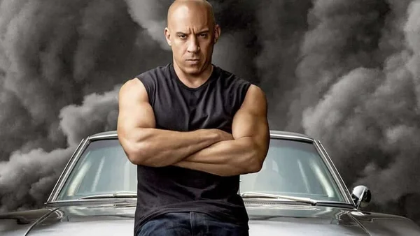 Vin Diesel incarne Dominic Toretto devant une voiture classique dans Fast & Furious.