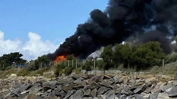 Une importante colonne de fumée noire s'élevant du site de l'explosion dans un camping à Pénestin.