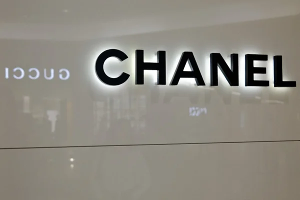 Défilé Chanel : un mannequin blond en robe noire et collier imposant ouvre la collection, applaudi par l'assistance.