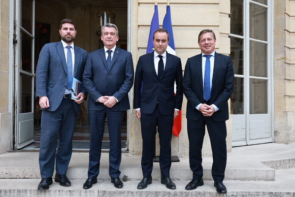 Sébastien Lecornu entouré de collègues devant un édifice officiel.