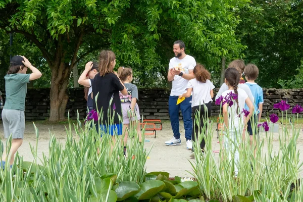 Un animateur sportif avec des enfants lors d'un Dimanche sportif dans un parc bordelais.