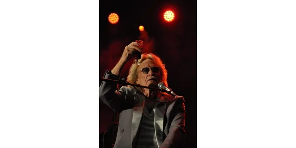Christophe lors d'un concert sur l'esplanade Lamartine, levant son verre en toast.