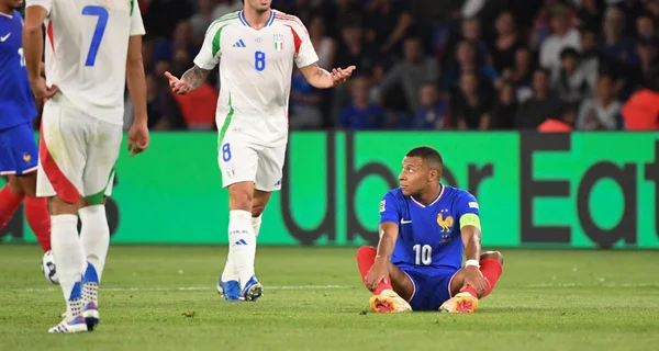 Un joueur des Bleus abattu après une action, face à un adversaire italien.