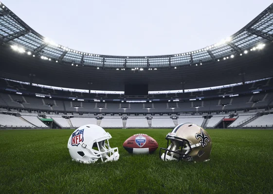 Casques et ballon de football américain aux couleurs de Paris sur la pelouse du Stade de France, en attendant le match historique.